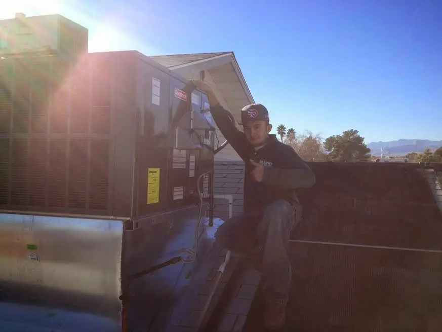 HVAC technician performing Air Duct Repair on a rooftop unit in Clarksburg
